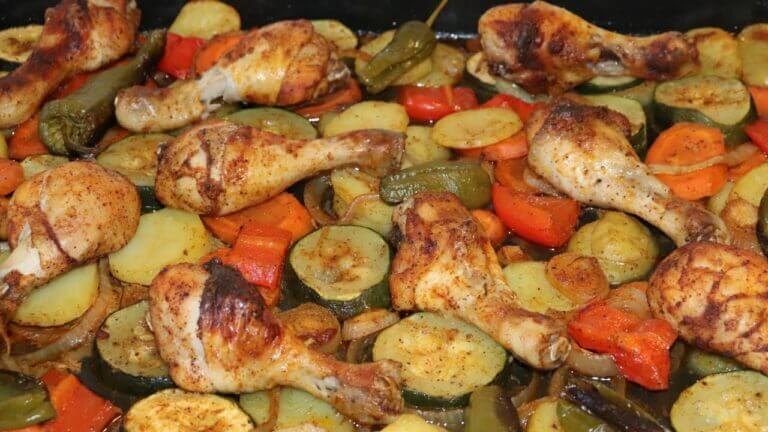 Pollo y verduras asadas en una bandeja para hornear